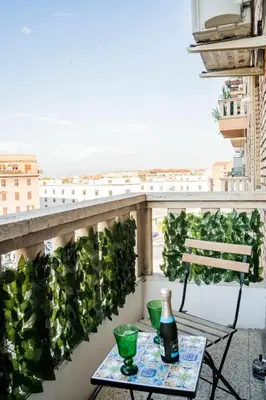 a table with a bottle of beer on a balcony at Casa Marta in Rome