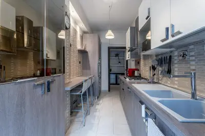 a large kitchen with blue sinks and brick walls at Naima Apartment San Pietro in Rome