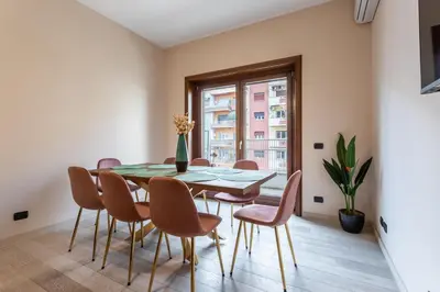 a dining room with a table and chairs and a window at Naima Apartment San Pietro in Rome