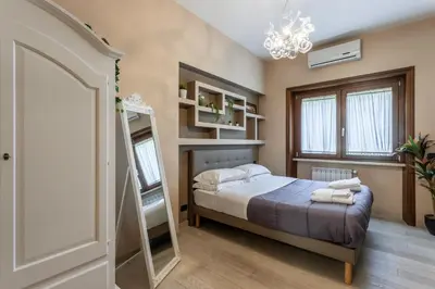 a bedroom with a bed and a chandelier at Naima Apartment San Pietro in Rome