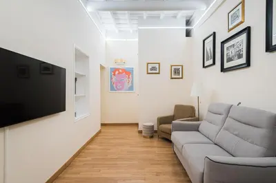 a living room with a couch and a flat screen tv at Lupa Luxury Apartment in Rome