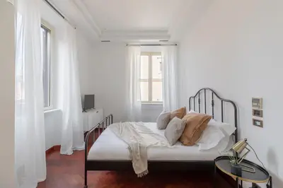 a white bedroom with a bed with white sheets and pillows at iFlat Veneto Area's Penthouse in Rome
