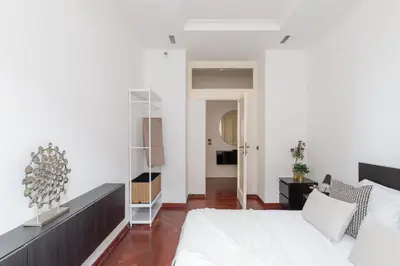 a bedroom with a white bed and a mirror at iFlat Veneto Area's Penthouse in Rome