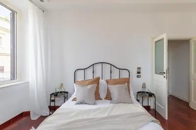 a bedroom with a bed with white sheets and pillows at iFlat Veneto Area's Penthouse in Rome