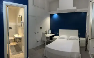 a bedroom with a white bed and a bathroom at Boutique Rooms in Rome