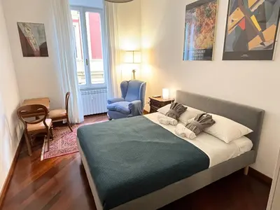a bedroom with a bed and a blue chair at Torlonia Rooms in Rome