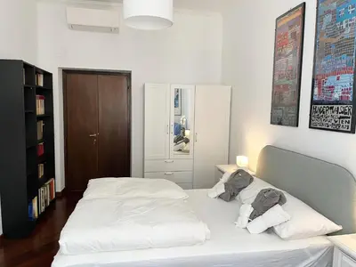 a bedroom with a white bed with two pillows at Torlonia Rooms in Rome