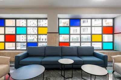 a living room with a blue couch in front of windows at Numa Rome Verso in Rome