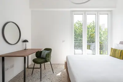 a bedroom with a bed and a desk and a mirror at Numa Rome Verso in Rome