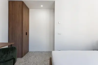 a room with a white refrigerator and a wooden door at Numa Rome Verso in Rome