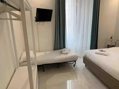 a small room with two beds and a tv at COLOSSEUM LUXURY HOME in Rome