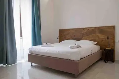 a bedroom with a large bed with a wooden headboard at COLOSSEUM LUXURY HOME in Rome