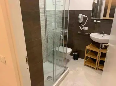 a bathroom with a shower with a toilet and a sink at COLOSSEUM LUXURY HOME in Rome