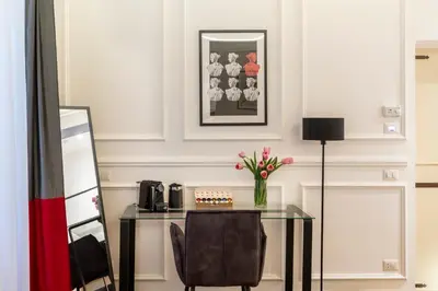 a table with a chair and a vase of flowers at Largo Arenula Suites in Rome