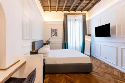 a hotel room with a bed and a tv at Largo Arenula Suites in Rome
