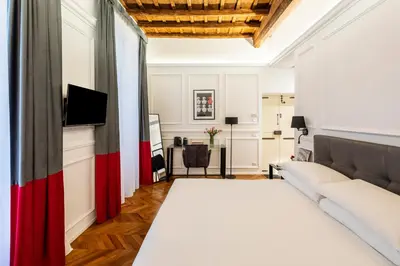 a bedroom with a large bed and a table at Largo Arenula Suites in Rome