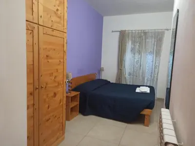 a bedroom with a bed and a dresser and a window at B&B Suite and Rooms San Giovanni in Rome