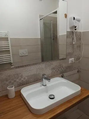 a bathroom with a white sink and a mirror at B&B Suite and Rooms San Giovanni in Rome