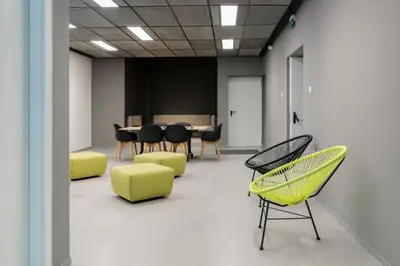 a meeting room with yellow and black chairs and a table at Dotcampus Roma City Center in Rome