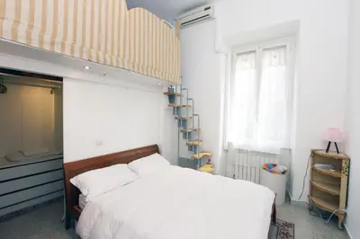 a bedroom with a large bed and a ladder at Angelo Emo Flat in Rome