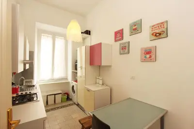a kitchen with a white refrigerator and a table at Angelo Emo Flat in Rome
