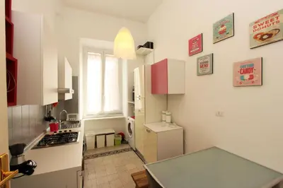 a small kitchen with a white refrigerator and a window at Angelo Emo Flat in Rome
