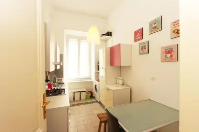 a kitchen with a refrigerator and a table in a room at Angelo Emo Flat in Rome