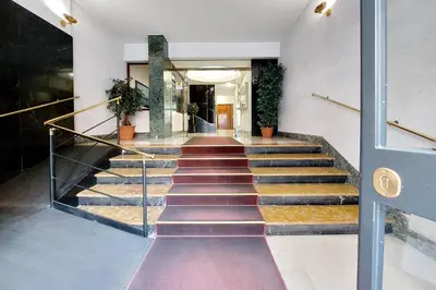 a hallway with stairs in a building with plants at Vatican Charme in Rome