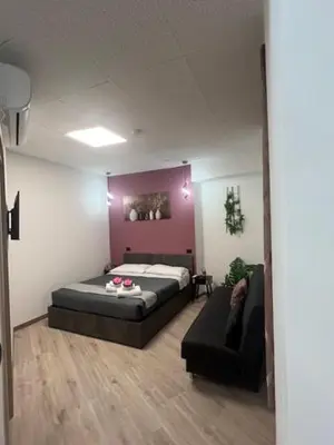a bedroom with a bed and a couch in a room at Lungotevere Testaccio 6 Roma - Apartments in Rome