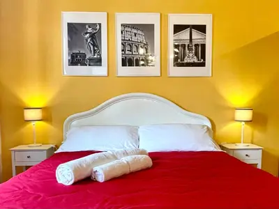 a bedroom with a red bed with pictures on the wall at Apt in front of the Vatican City in Rome