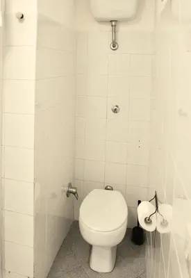 a white bathroom with a toilet and a sink at Apt in front of the Vatican City in Rome