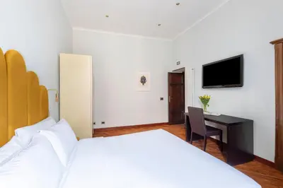 a bedroom with a bed and a desk and a tv at DEZA Case vacanza Nazionale Joy e Living in Rome