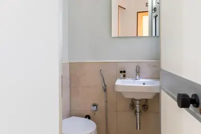 a bathroom with a sink and a toilet and a mirror at DEZA Case vacanza Nazionale Joy e Living in Rome