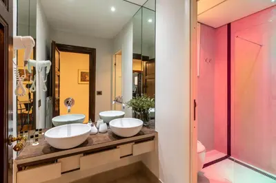 a bathroom with two sinks and a mirror at DEZA Case vacanza Nazionale Joy e Living in Rome