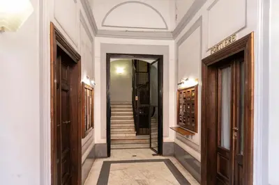 a hallway with white walls and wooden doors at DEZA Case vacanza Nazionale Joy e Living in Rome