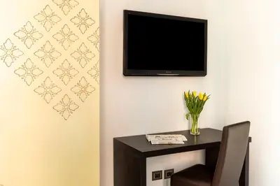 a room with a table and a tv on the wall at DEZA Case vacanza Nazionale Joy e Living in Rome
