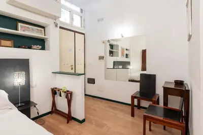 a bedroom with a bed and a desk and a mirror at Old Trastevere Studio in Rome