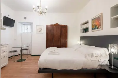 a bedroom with a bed and a table and a chandelier at Old Trastevere Studio in Rome