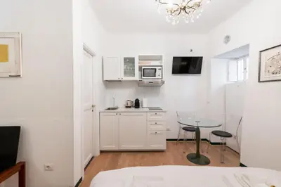 a white kitchen with a table and a microwave at Old Trastevere Studio in Rome