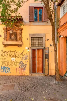 a building with graffiti on the side of it at Old Trastevere Studio in Rome