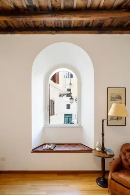 an arched window in a living room with a couch at Pantheon Caravaggio's House in Rome