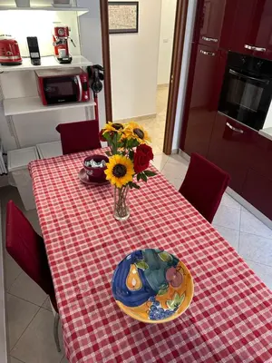 a table with a plate and a vase of flowers on it at Royal Domus Of Rome in Rome