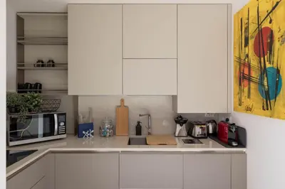 a kitchen with white cabinets and a microwave at iFlat Shiny Loft in Trastevere in Rome