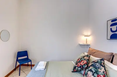 a bedroom with a bed and a blue chair at Residenza Como in Rome