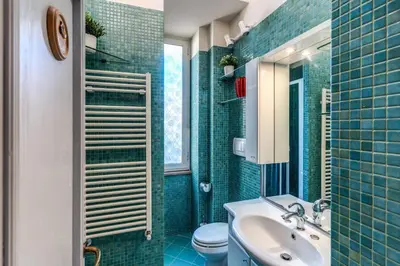 a bathroom with a sink and a toilet and blue tiles at Residenza Como in Rome
