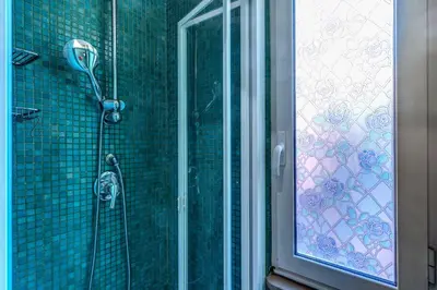 a shower in a bathroom with a glass door at Residenza Como in Rome