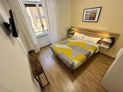 a bedroom with a bed with a yellow and gray comforter at Rhome Holiday Fornaci in Rome