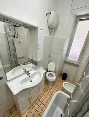 a white bathroom with a sink and a toilet at Rhome Holiday Fornaci in Rome