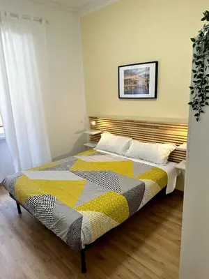 a bedroom with a bed with a yellow and gray blanket at Rhome Holiday Fornaci in Rome