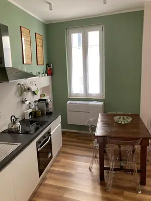 a kitchen with a wooden table and a kitchen with green walls at Casa MANÍ Campo de Fiori in Rome